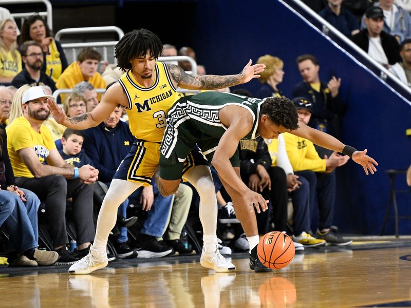Michigan State's Jeremy Fears Jr. kicks Michigan's Elliot Cadeau during the first half Sunday.