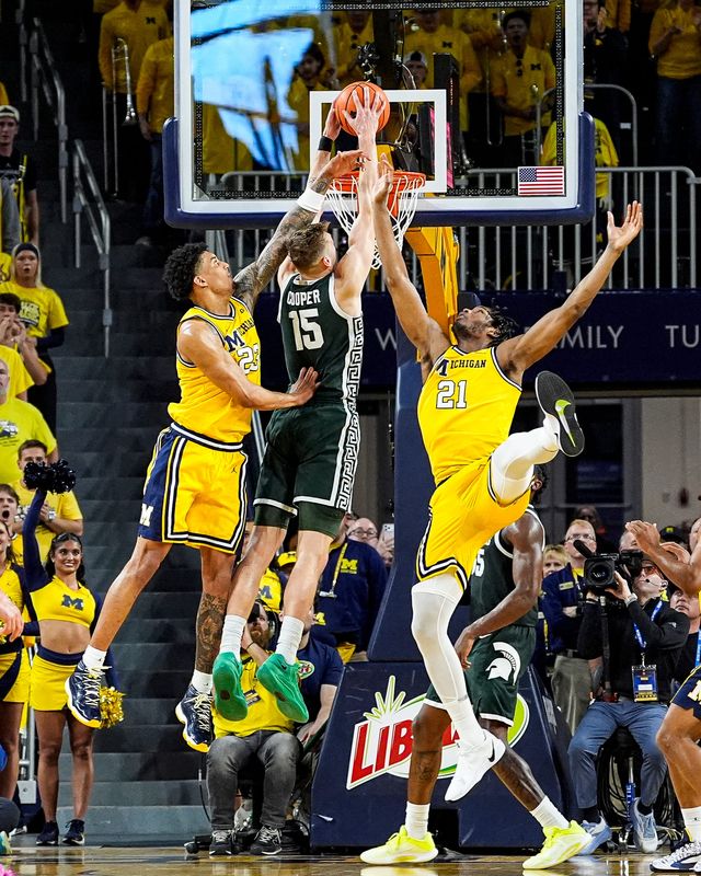 Michigan State center Carson Cooper (15) dunks against Michigan forward Yaxel Lendeborg (23) and forward Morez Johnson Jr. (21) during the second half at Crisler Center in Ann Arbor on Sunday, March 8, 2026.