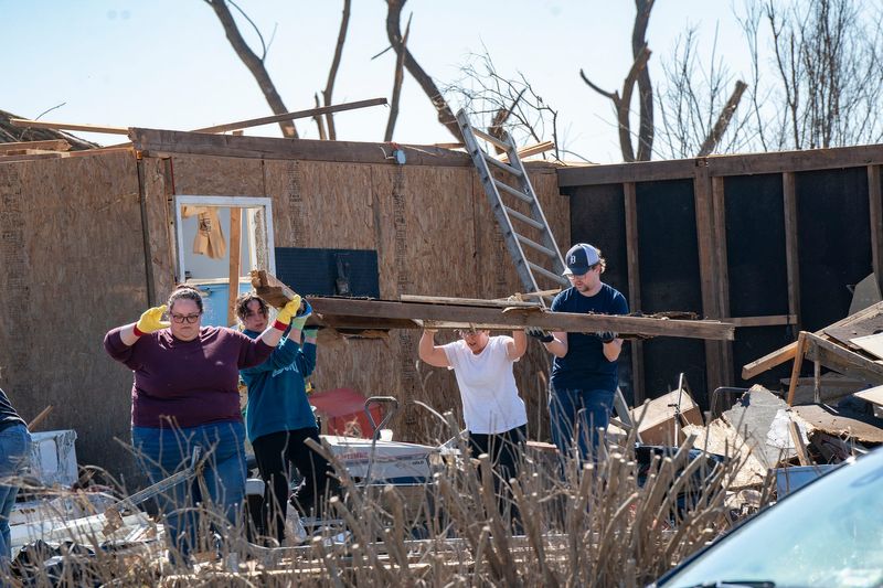 People work together to clean up debris on Monday, March 9, 2026, after a tornado devastated this area on Union Lake on Friday, March 6, 2026.