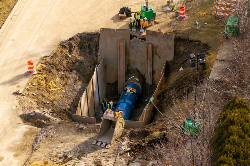 Utility crews work on repairing a water main break on 14 Mile Road east of Drake, in Farmington Hills, March 9, 2026.