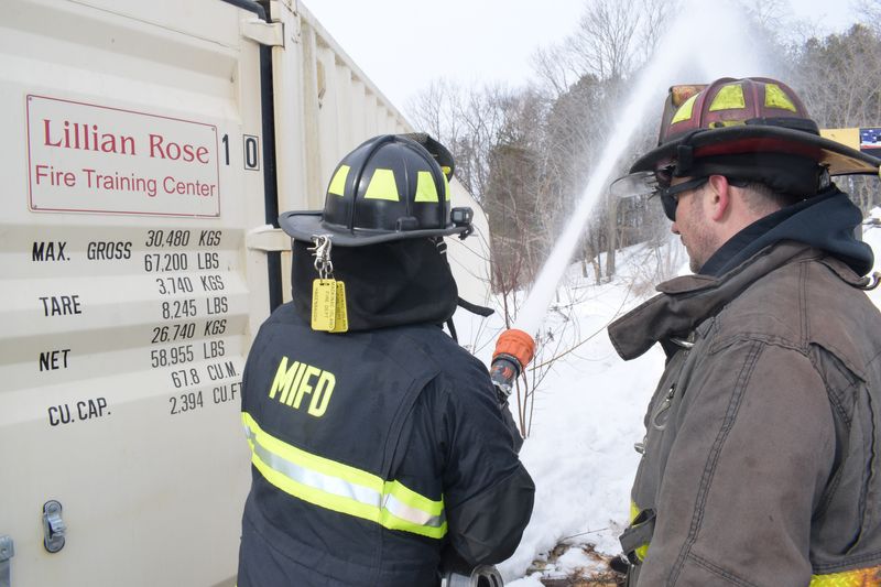 A Detroit firefighter works with aÊMackinac Island firefighter James Alford Hagenbaugh onÊfire hose training on Saturday, Feb. 28, 2026.