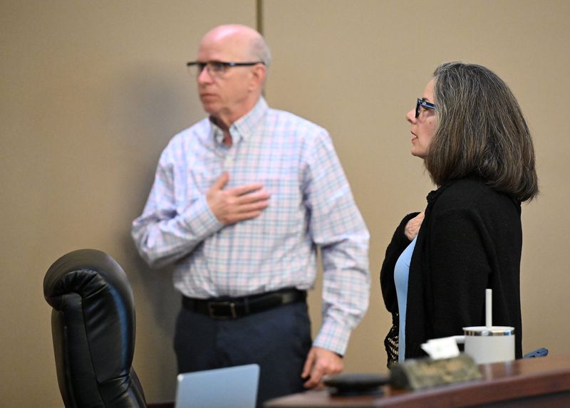 From left, Plymouth Township Treasurer Bob Doroshewitz and Trustee Jen Buckley say the pledge of allegiance during a Plymouth Township board meeting in Plymouth Township, Mich. on March 10, 2026.