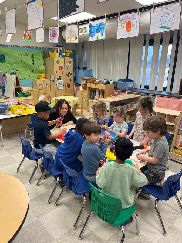 Alexandra Masy-alhin, an apprentice teacher through the MiEarly Apprentice program, makes sparkle play dough with her pre-K kids.