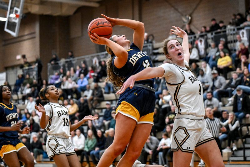 DeWitt's Carly Dennis, left, scores as Holt's Chloe Buckley defends during the fourth quarter on Wednesday, March 11, 2026, at Holt High School.