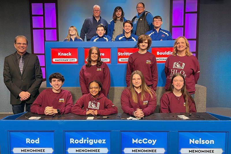 Representing Mackinaw City (seated from left) are players Naomi Knack, Tyler Allaire, team captain Ben Strittmatter and Will Bouldin. Standing is alternate Nathaniel Petoskey with coach Jeff Curth and Amanda Munger. Players for Menominee are (seated from left) Travis Rod, Melanie Rodriguez, team captain Lizzie McCoy and Karley Nelson. Standing are alternates Kaylee Galloway and Liam Larson with coach Anne Burmeister. High School Bowl host Jim Koski is standing at lower left.