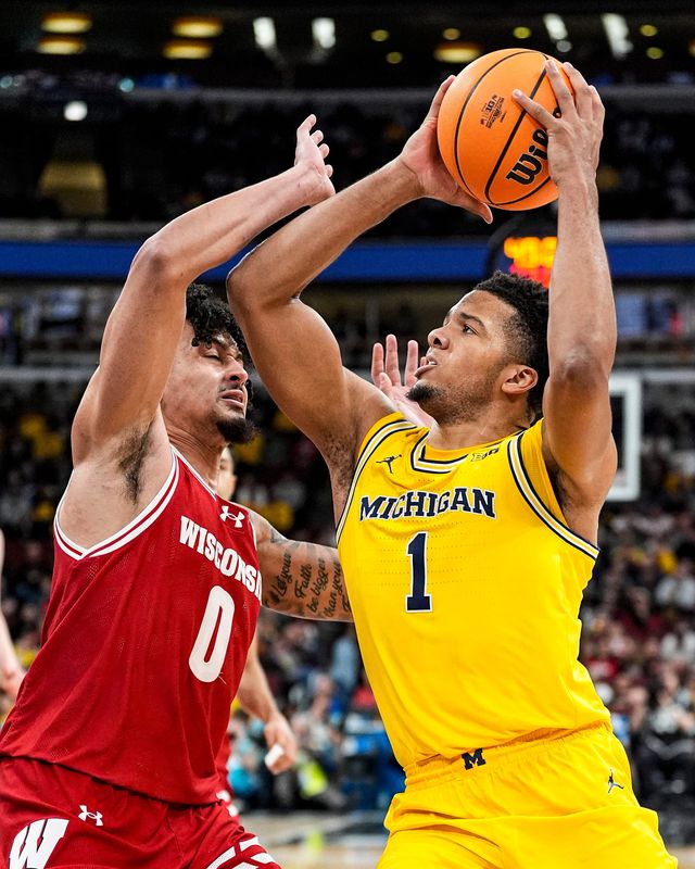 Michigan guard Trey McKenney (1) goes to the basket against Wisconsin guard Braeden Carrington (0) during the first half of Big Ten Tournament semifinal at United Center in Chicago on Saturday, March 14, 2026.