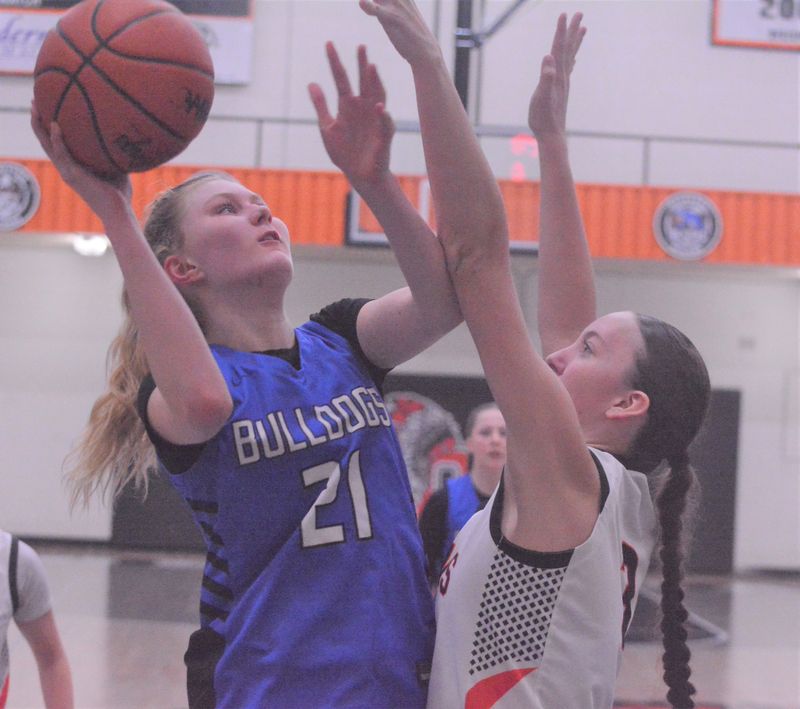 Inland Lakes sophomore center Ava Belford (21) puts up a shot over Newberry junior Natalie Whalen during the second half of an MHSAA Division 4 girls basketball regional final at Cheboygan on Saturday, March 14. Belford finished with a game-high 15 points for the Bulldogs in the win.