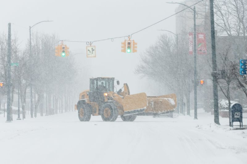 Heavy equipment travels on State Street during a snowfall Sunday, March 15, 2026 in Traverse City, Mich.