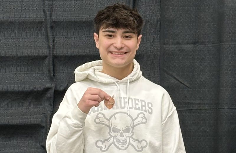 Jace Starll of Gibraltar Carlson shows off his fifth-place medal at the Division 2 state finals at Eastern Michigan on Saturday, March 14, 2026.