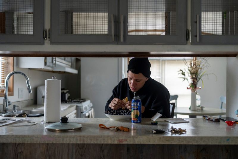 Carlos Santodomingo Sánchez, 29, eats a quick meal at home before starting his DoorDash shift in Ypsilanti on Wednesday, March 4, 2026.