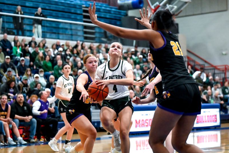 Portland St. Patrick's Lily Sandborn, center, moves to the basket between Concord's Bradie Lehman, left, and Julia White during the second quarter on Tuesday, March 17, 2026, at Mason High School.