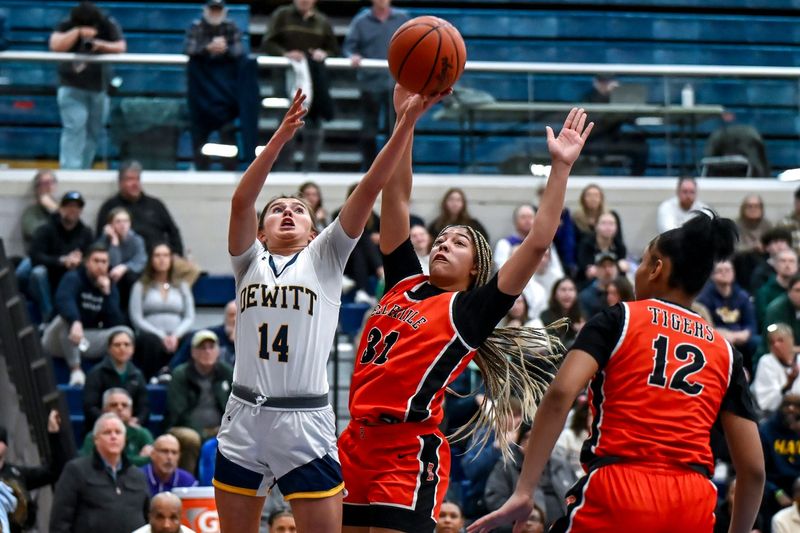 DeWitt's Sophia Beland, left, scores as Belleville's Sydney Savoury defends during the first quarter on Tuesday, March 17, 2026, at Mason High School.