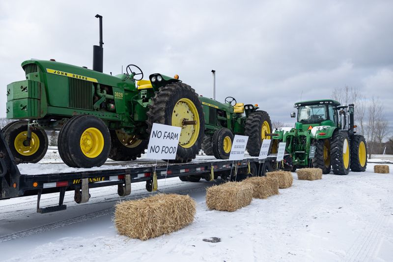A farmer displays tractors on a trailer with signs outside Evergreen Ministries ahead of RWE’s presentation on its proposed solar energy project on Tuesday, March 17, in Hudsonville.