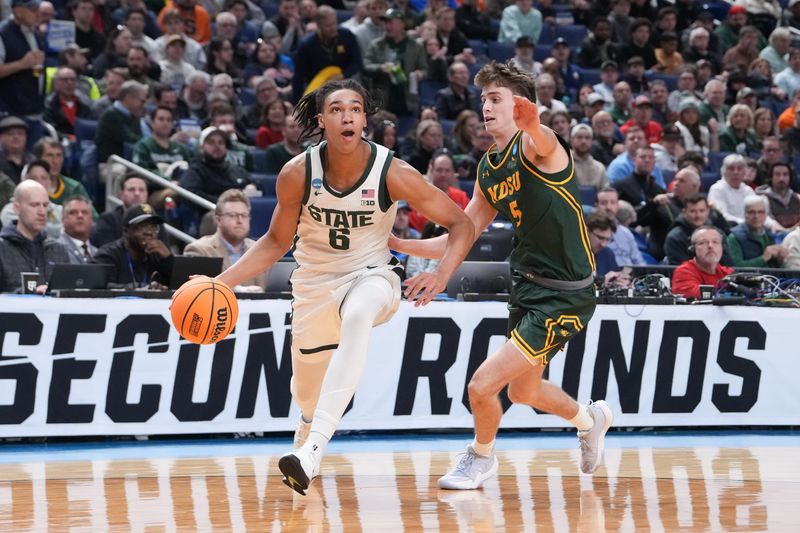 Mar 19, 2026; Buffalo, NY, USA; Michigan State Spartans forward Jordan Scott (6) drives to the basket against North Dakota State Bison guard Andy Stefonowicz (5) during the first half during a first round game of the men's 2026 NCAA Tournament at Keybank Center. Mandatory Credit: Gregory Fisher-Imagn Images