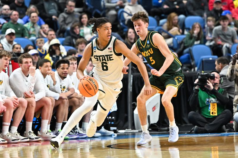 Mar 19, 2026; Buffalo, NY, USA; Michigan State Spartans forward Jordan Scott (6) dribbles and looks to pass as North Dakota State Bison guard Andy Stefonowicz (5) defends during the first half during a first round game of the men's 2026 NCAA Tournament at Keybank Center. Mandatory Credit: Mark Konezny-Imagn Images