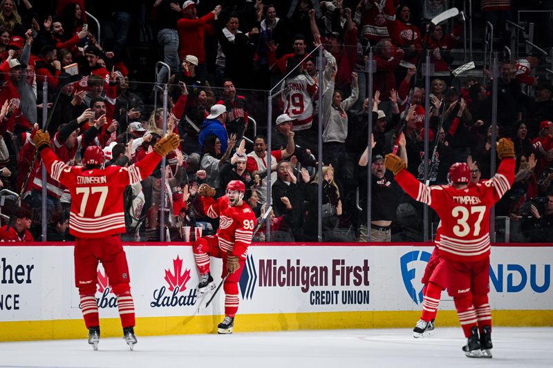 Detroit Red Wings right wing Alex DeBrincat (93) celebrates with defenseman Simon Edvinsson (77) and left wing J.T. Compher (37) after scoring a goal during the third period against the Montreal Canadiens at Little Caesars Arena in Detroit on Thursday, March 19, 2026.