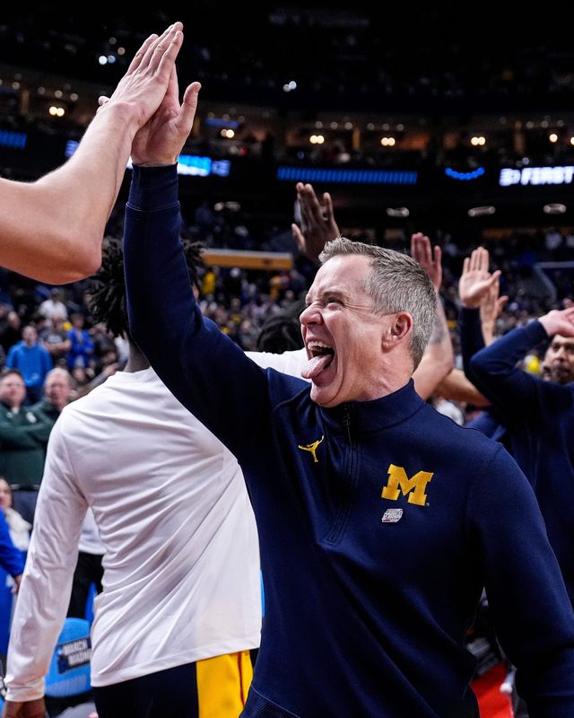 Michigan head coach Dusty May high-fives players after 95-72 win over Saint Louis at the NCAA Tournament Second Round at KeyBank Center in Buffalo on Saturday, March 21, 2026.