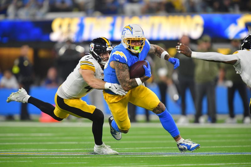 Nov 9, 2025; Inglewood, California, USA; Los Angeles Chargers tight end Tyler Conklin (83) carries the ball defended by Pittsburgh Steelers linebacker Payton Wilson (41) during the third quarter of the game at SoFi Stadium. Mandatory Credit: Gary A. Vasquez-Imagn Images