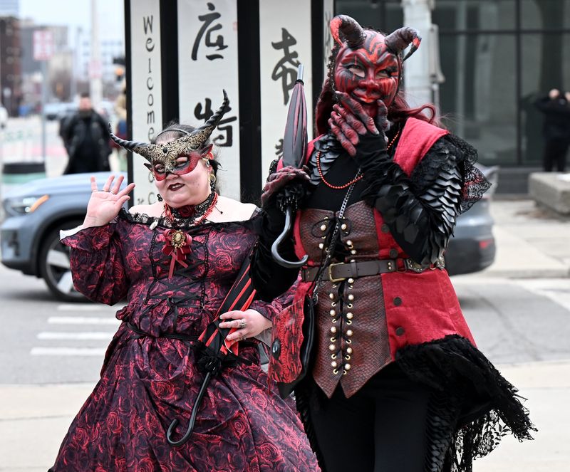 From left, Alexis Anthony, 38, of Warren and Jenna Catallo, 36, of Lansing walk and pose for a photo after the Marche du Nain Rouge in Detroit on Mar. 22, 2026.