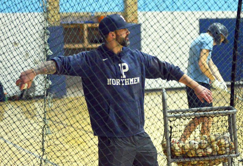 First-year Petoskey baseball coach Matt Henning works in the cage during an indoor practice at Petoskey High School. For the first time in over 15 years, PHS will have a new leader within the program.