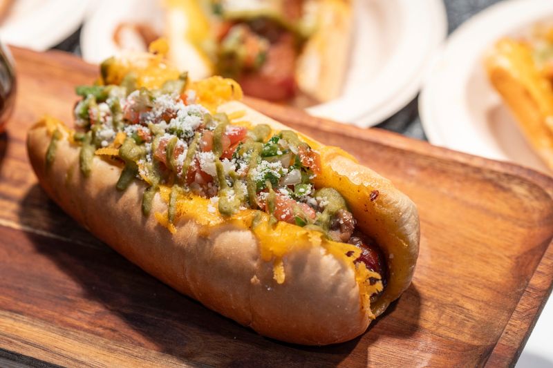 Grilled cheese Sonoran dog made with a bacon wrapped hot dog, beans, pico de gallo, cojita cheese, on top of a grilled cheese bun made by Taqueria El Rey that will be sold during the season is on display during the 2026 “What’s New at Comerica Park” annual media event at Comerica Park in Detroit on Wednesday, March 25, 2026.