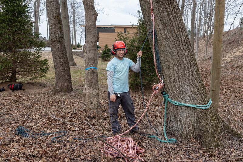 Ried Meyer poses for a photo before removing a defective maple March 26 near Lake Michigan.