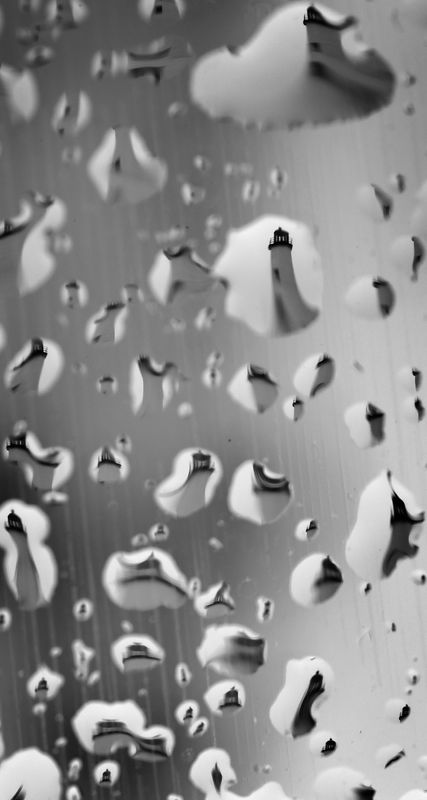 Light rain gathers on a car window parked near Scituate Light which is reflected in the raindrops on the windshield on Monday March 16, 2026