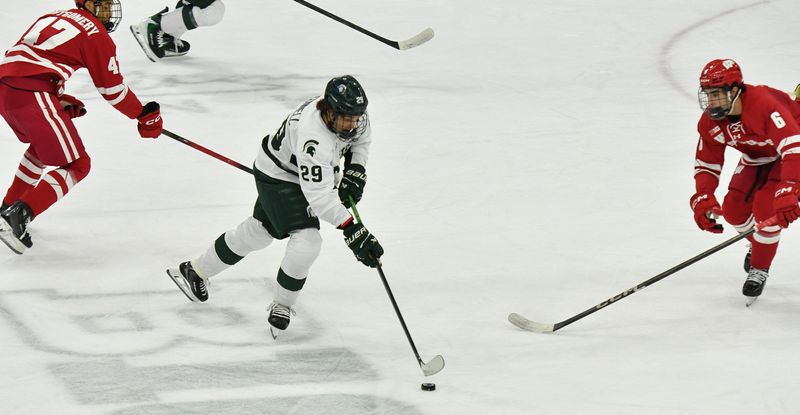 Michigan State's Gavin O'Connell (29) looks to pass as Wisconsin's Logan Hensler (6) defends Saturday, Nov. 22, 2025 at Munn Arena.