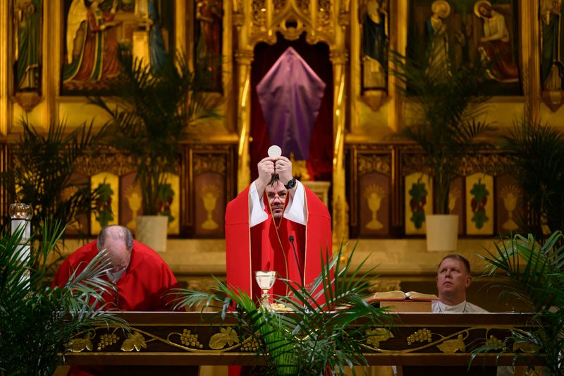 Rev. Ryszard Czerniak prepares the holy communion during a Palm Sunday mass at St. Florian Catholic Church in Hamtramck on March 29, 2026. Czerniak said he is guessing the church will remain open after the Archdiocese of Detroit finishes its restructuring process.