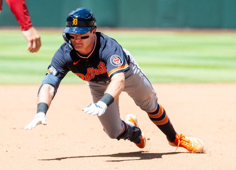 Tigers third baseman Kevin McGonigle dives into third after hitting a triple in the sixth inning against the Diamondbacks at Chase Field.