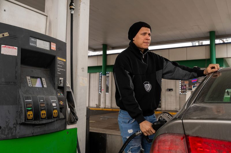 Carlos Santodomingo, 29, fills his car with gas during a break from delivering food through DoorDash in Ypsilanti on Wednesday, March 4, 2026.