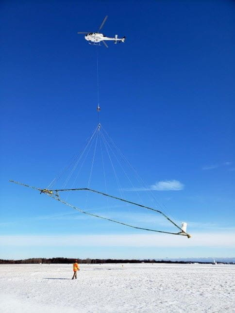 Helicopter equipped with a towed “hoop” that is deployed about 100 feet beneath the helicopter when in flight to assist in to mapping geology and aquifers.