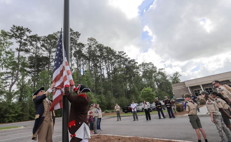 US Coast Guard Ret. Capt. Roger Coursey and Ret. Sgt 1st Class, Robert Brooks lower the American flag during a ceremony to retire the worn flag and replace it with a new one on Saturday, April 4, 2026, at the Savannah Scottish Rite.