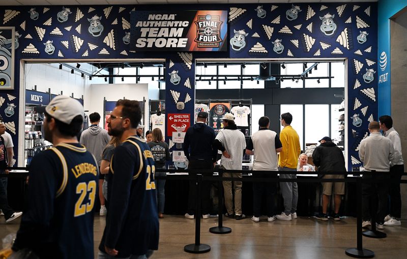 Fans look at merchandise before the game as Michigan takes on Arizona in the NCAA men’s basketball championship semifinal.