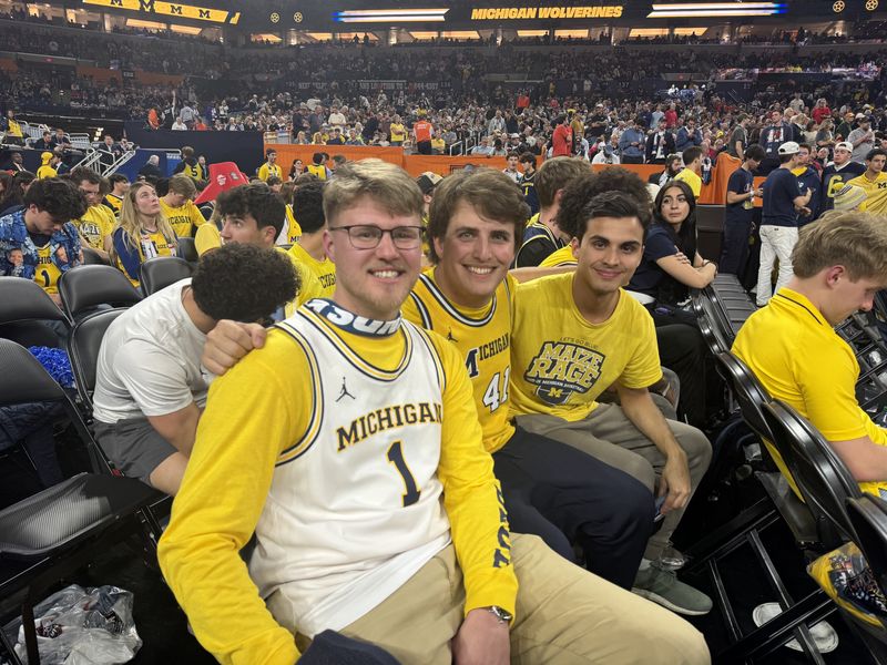 From left to right: University of Michigan students Kolbe Watson, 25, Charlie Thompson, 21, and Flynn Goel, 22, pose in the "Maize Rage" section during the second half.