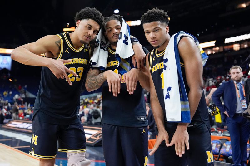 Michigan forward Yaxel Lendeborg (23), guard Roddy Gayle Jr. (11) and guard Trey McKenney (1) pose for a photo following their Final Four win against Arizona at Lucas Oil Stadium in Indianapolis on Saturday, April 4, 2026.