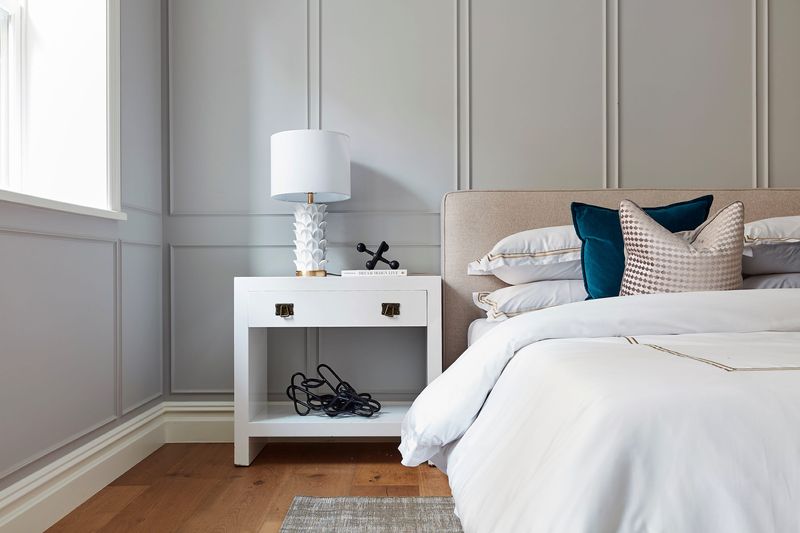 Wood paneling is used as an architectural element in a master bedroom. (