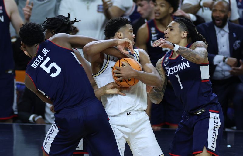Apr 6, 2026; Indianapolis, IN, USA; UConn Huskies forward Tarris Reed Jr. (5) fouls Michigan Wolverines guard Trey McKenney (1) in the second half during the national championship of the Final Four of the men's 2026 NCAA Tournament at Lucas Oil Stadium. Mandatory Credit: Trevor Ruszkowski-Imagn Images