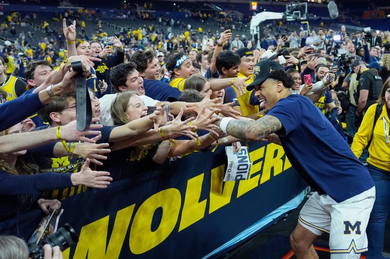 Michigan forward Yaxel Lendeborg (23) high-fives fans as they celebrate the NCAA national championship after the team beat Connecticut at Lucas Oil Stadium in Indianapolis on Monday, April 6, 2026.
