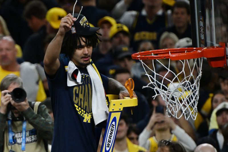 Michigan’s Elliot Cadeau cuts down a piece of net after beating UConn in the NCAA Final in Indianapolis, Indiana on April 6, 2026.