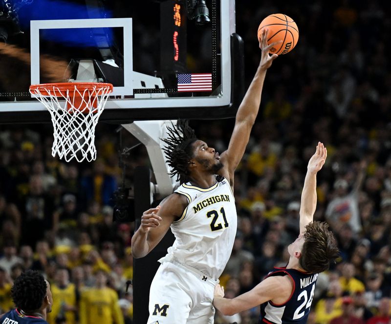 Michigan forward Morez Johnson Jr. (21) blocks a shot by UConn guard Braylon Mullins (24) in the second half as Michigan takes on UConn at the NCAA men’s basketball championship at Lucas Oil Stadium on April 6, 2026 in Indianapolis.
