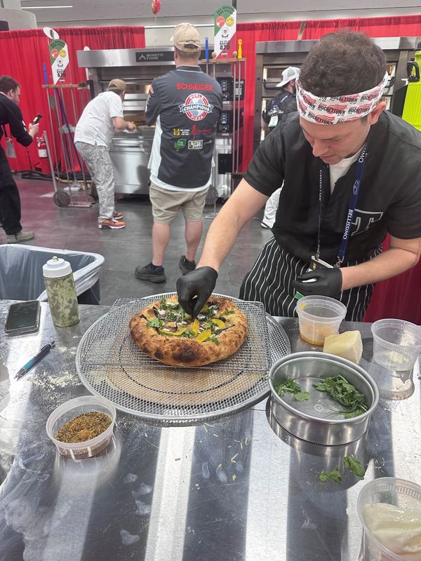 Michael Baldwin puts toppings on his competition pizza at the International Pizza Expo in Las Vegas.