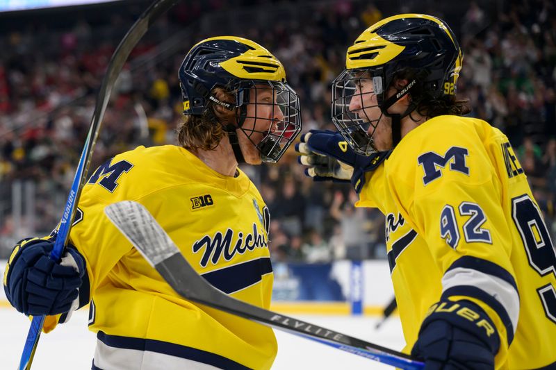 Michigan forward T.J. Hughes, left, and Michigan forward Adam Valentini celebrate after Hughes scored a goal during the first period of the Frozen Four semifinal between Michigan and Denver, at T-Mobile Arena, in Las Vegas, April 9, 2026.