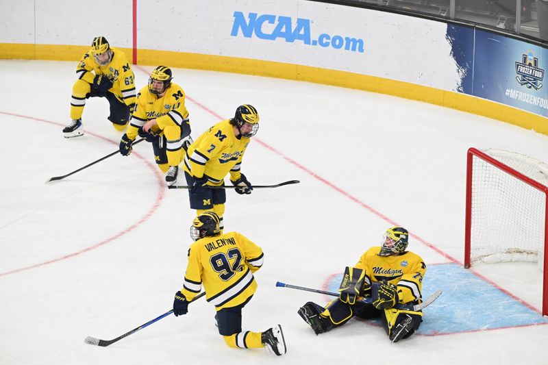 Michigan players react after losing 4-3 in overtime against Denver in the Frozen Four semfinal.