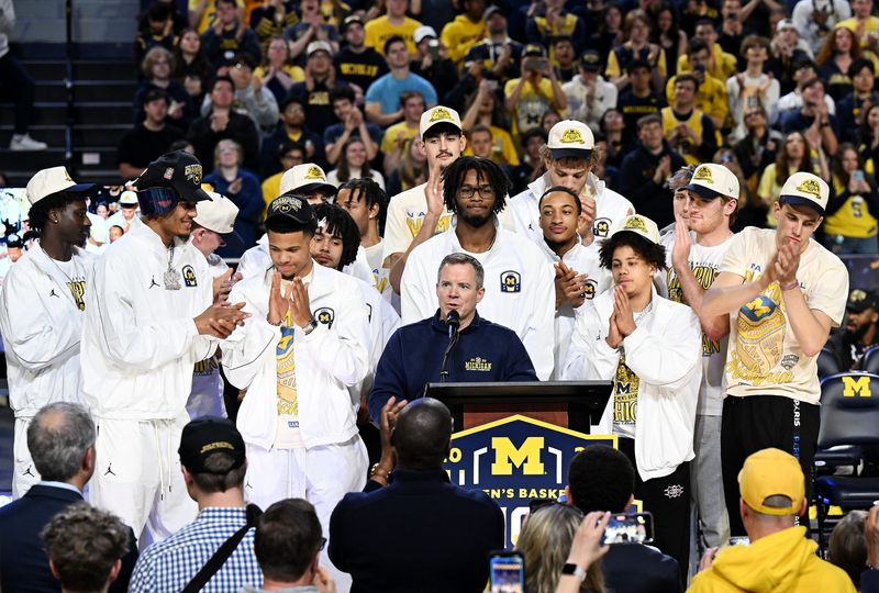 Michigan head coach Dusty May speaks surrounded by the team during the celebration for the 2026 Michigan Men’s Basketball National Championship team at Crisler Center on April 11, 2026 in Ann Arbor, Mich.