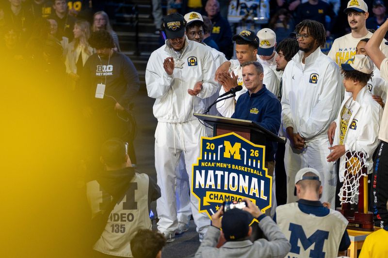 Michigan head coach Dusty May stands at the podium as players look on during a celebration honoring the Wolverines’ NCAA men’s basketball national championship at Crisler Center in Ann Arbor on Saturday, April 11, 2026.