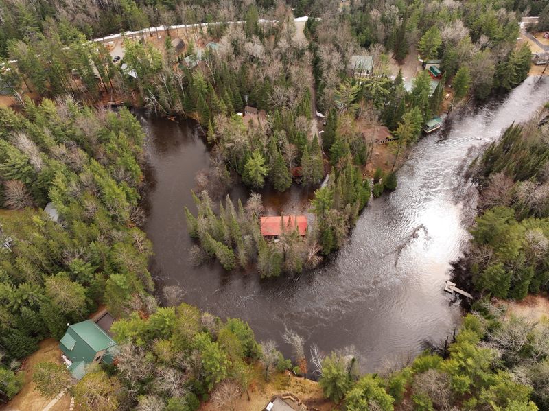 A swollen Au Sable River is seen from an aerial view in South Branch Township in Crawford County between Grayling and Mio on Monday, April 13, 2026. There are flood warnings in place for the Au Sable River this week due to heavy rainfall.