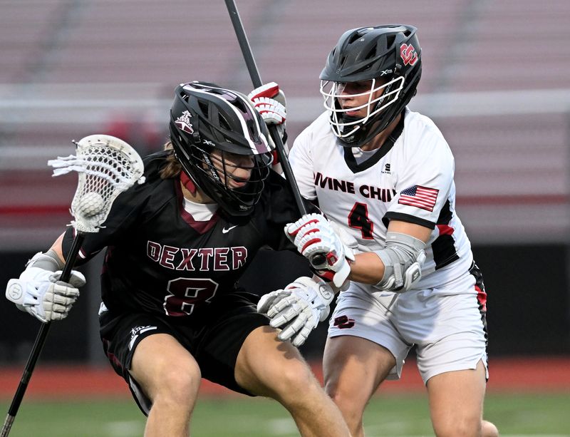Divine Child junior Nick Ratcliffe, right, defends Dexter junior Dawson Waddington, left, in the first half as Divine Child takes on Dexter in boy’s lacrosse at Divine Child High School on April 13, 2026 in Dearborn, Mich.