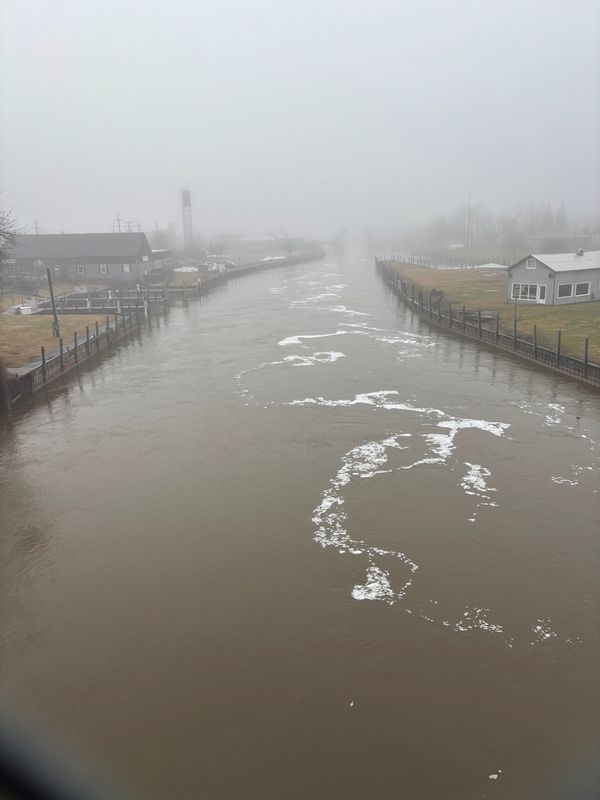 The Cheboygan River upstream from the Cheboygan Lock & Dam Complex, races under a footbridge toward Lake Huron, Tuesday, April 14, 2026.