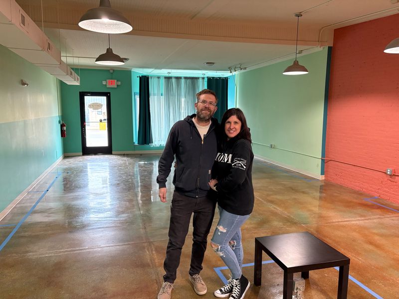 Seth and Stephanie Perrin pose for a photo in their future bookstore in downtown Howell.